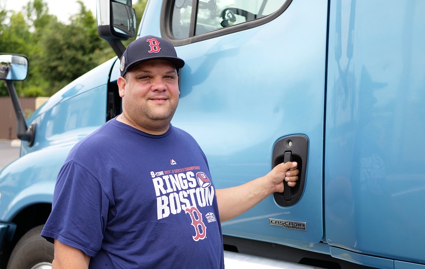 A Status Transportation Corp owner operator stands by his truck.